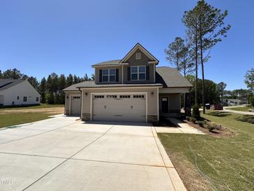 Charming two-story home featuring a three-car garage and well-manicured lawn on a bright, sunny day at 18 Bonnybrook Ct, Selma, NC 27576