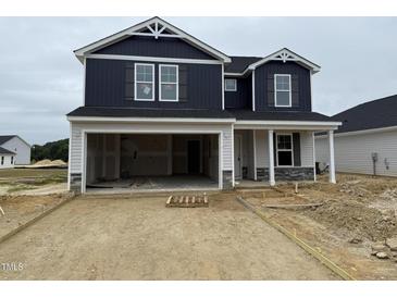 New two-story home featuring dark siding, a two-car garage, and stone accents at 18 W Emily Gardens Dr, Selma, NC 27577