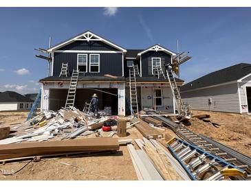 This is the front exterior of a two-story home under construction with a dark blue facade and white trim at 18 W Emily Gardens Dr, Selma, NC 27577