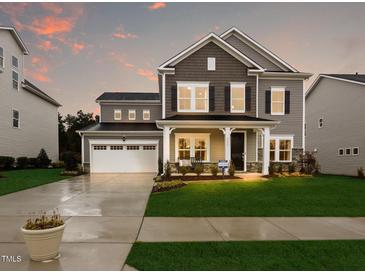 Charming two-story home featuring a manicured lawn, two-car garage, and inviting front porch at 205 E Fountainhead Ln # 159, Garner, NC 27529