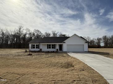 Charming single-story home featuring a classic white facade and a two-car garage at 225 Phil Jack Rd, Dunn, NC 28334