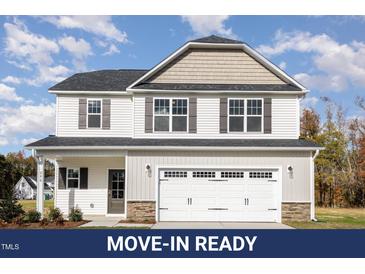 Charming two-story home featuring a large garage and appealing neutral-colored siding at 246 Trescott St, Smithfield, NC 27577