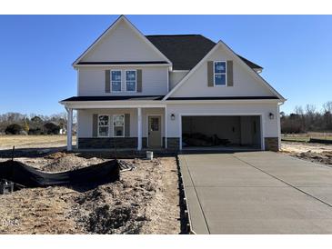 New two-story home featuring a two car garage, stone accents, and newly poured driveway at 253 Trescott St, Smithfield, NC 27577