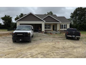 A single-Gathering home featuring a spacious garage, complemented by a black pickup truck at 28 Bailey-Boykin Rd, Selma, NC 27576