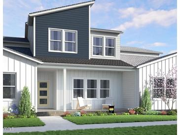 Beautiful two-story home featuring modern architecture, lush landscaping, and a welcoming front porch at 815 Central Park Dr, Knightdale, NC 27604