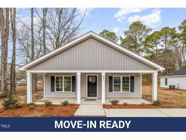 Charming home featuring a covered front porch and neatly landscaped front yard at 307 E Pope Ave, Kenly, NC 27542