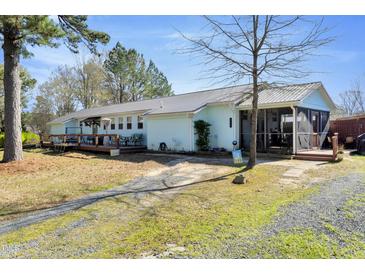 This property features a lengthy, single-story design, a gravel driveway, and a charming screened porch at 309 14Th St, Butner, NC 27509