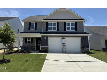 Charming two-story home with a gray exterior, a two-car garage, and a well-manicured lawn at 33 W Emily Gardens Dr, Selma, NC 27576
