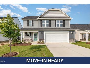 Charming two-story home with gray siding, black shutters, and a welcoming front porch at 33 W Emily Gardens Dr, Selma, NC 27576