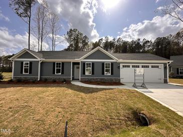 Charming one-story home with gray siding, black shutters, and a manicured lawn on a sunny day at 39 N Rowsham Pl, Smithfield, NC 27577