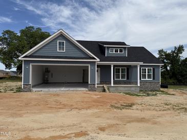 Charming single-story home boasts an attached two-car garage and a covered front porch at 40 Bailey-Boykin Rd, Selma, NC 27576