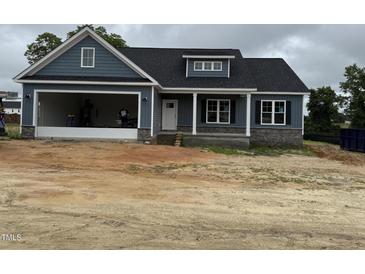 Charming blue home with gray stone accents, a garage, and covered porch for a modern and inviting feel at 40 Bailey-Boykin Rd, Selma, NC 27576