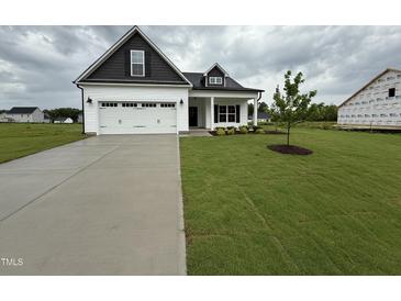 Charming single-Gathering home featuring a well-maintained lawn and an attached two-car garage at 40 Tuskeegee Dr, Smithfield, NC 27577