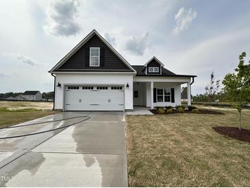 Charming new construction home featuring a two-car garage, black accents, and a well-manicured lawn at 40 Tuskeegee Dr, Smithfield, NC 27577
