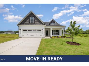 Charming home with white siding, black accents, and a well-manicured lawn at 40 Tuskeegee Dr, Smithfield, NC 27577