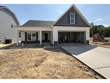 Charming single-story home featuring a light grey exterior, an attached garage, and a well-manicured front yard at 41 W Emily Gardens Dr, Selma, NC 27576