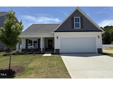 Charming one-story home with a two-car garage, landscaped yard, and inviting covered front porch at 41 W Emily Gardens Dr, Selma, NC 27576