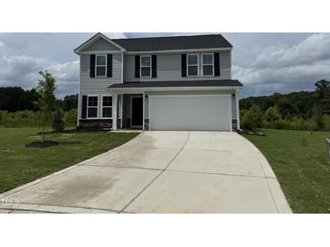 Two story home featuring a two car garage, black shutters, and concrete driveway at 43 Chloe Ct, Selma, NC 27576