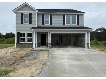 Two-story home with gray siding, black shutters, and a spacious two-car garage at 43 Chloe Ct, Selma, NC 27577