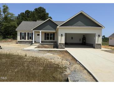 Charming one-story home showcasing a welcoming front entrance and an attached two-car garage at 47 Royal Ave, Selma, NC 27576