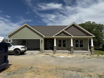 New construction shows a charming one-story home with stone accents and a two-car garage at 56 Bailey-Boykin Rd, Selma, NC 27576