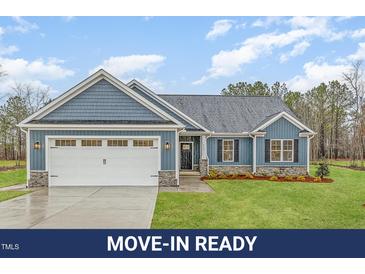Charming home featuring a blue exterior, shingle accents, a two-car garage, and a well-maintained lawn at 613 Tuscany Cir, Princeton, NC 27569