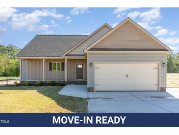 Charming single-story home with a two-car garage, well-manicured lawn, and inviting curb appeal at 68 Tee Dr, Selma, NC 27576