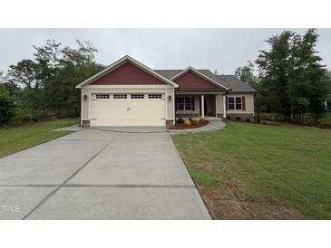 Charming single-story home featuring a spacious driveway, attached garage, and well-maintained lawn at 702 Tuscany Cir, Princeton, NC 27569
