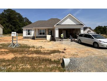 Charming one-story home featuring stone accents and a two-car garage and newly installed windows at 71 Royal Ave, Selma, NC 27576