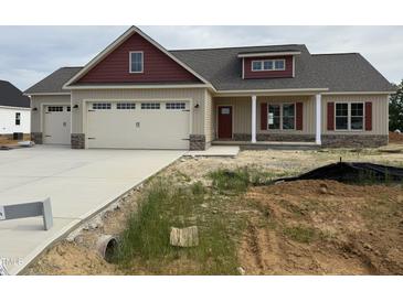A charming home featuring a two-car garage, red accents, and a partially landscaped front yard at 76 Royal Ave, Selma, NC 27576