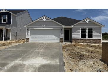 Charming single-story home featuring a two-car garage and stone accents at 8 W Emily Gardens Dr, Selma, NC 27577