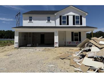 New construction home with white siding, black shutters, and an attached two-car garage at 82 W Emily Gardens Dr, Selma, NC 27577