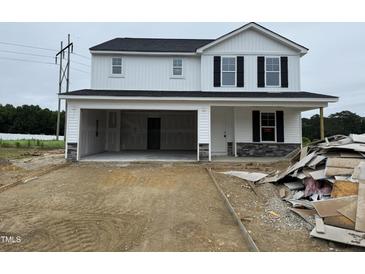 Charming two-story home with a convenient attached two-car garage and unfinished landscape at 82 W Emily Gardens Dr, Selma, NC 27577