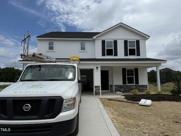 Two-story white home with black shutters, stone accents, and a newly installed yard at 82 W Emily Gardens Dr, Selma, NC 27576