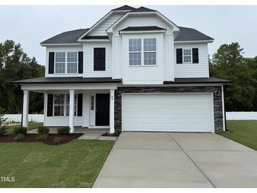 Charming two-story home featuring a two-car garage and a welcoming front porch at 83 W Emily Gardens Dr, Selma, NC 27576