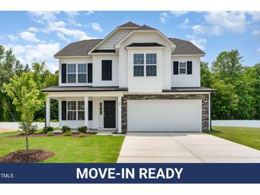 Charming two-story home with white siding, black shutters, and a well-manicured front lawn at 83 W Emily Gardens Dr, Selma, NC 27576