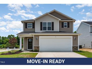 Charming two-story home showcasing a two-car garage, neutral siding, and a well-manicured front lawn at 9 W Emily Gardens Dr, Selma, NC 27576
