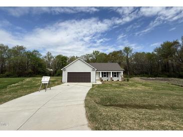 Charming single-story home with a well-manicured lawn and a two-car garage at 91 Harvest Hills Ln, Dunn, NC 28334