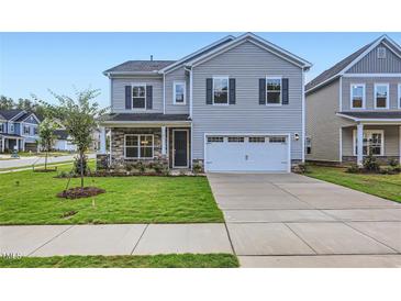 Charming two-story home with stone accents, a two-car garage, and well-manicured lawn at 103 Ellsworth Ct # 175, Garner, NC 27529