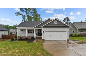 Charming home with a two-car garage, covered porch, and well-manicured lawn and shrubbery at 105 Jasper Creek Ct, Wilson's Mills, NC 27520