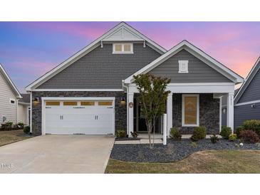 Charming single-Gathering home featuring a stone facade, well-manicured landscaping, and a two-car garage at 1217 Linkwood Way, Fuquay Varina, NC 27526