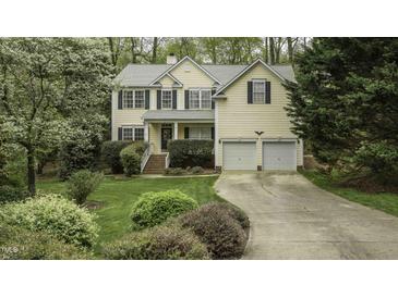 Charming two-story home featuring a well-manicured lawn, lush landscaping, and a two-car garage at 1505 Starmont Dr, Hillsborough, NC 27278