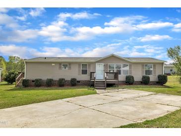 Inviting single-story home with a well-manicured lawn, complemented by a concrete driveway and covered front porch at 162 E Abbey Ct, Smithfield, NC 27577