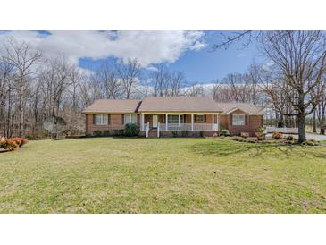 Lovely red brick ranch home featuring a charming front porch and a well-manicured lawn at 1635 Sandy Cross Rd, Burlington, NC 27217