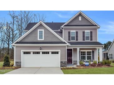 Charming two-story home with gray siding, a black roof, and a two car garage at 189 Tennyson Dr # 236, Garner, NC 27529