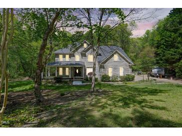 Charming home featuring beautiful landscaping, a spacious front porch, and abundant natural light from many windows at 1900 High Oaks Ln, Raleigh, NC 27606