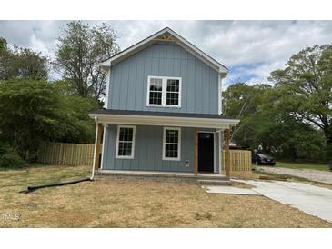 Charming two-story home featuring blue siding, a welcoming front porch, and manicured lawn at 207 Sallinger St, Knightdale, NC 27545