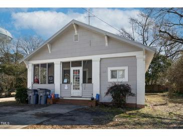 Charming bungalow-style home with gray siding, brick accents, and a screened-in front porch at 257 E Raleigh Blvd, Rocky Mount, NC 27801