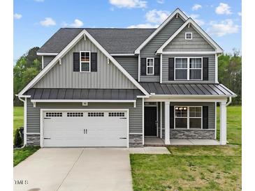 Charming two-story home with a gray exterior, a two-car garage, and a well-manicured lawn at 396 Martins Mill Ct, Wendell, NC 27591
