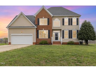 Charming two-story home features a brick facade, black shutters, and a well-manicured lawn at 4905 Homestead Dr, Mebane, NC 27302